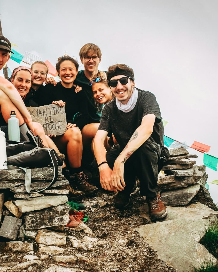 A group of travelers resting together at the top of a mountain pass
